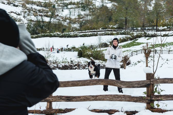 Happy woman play snowballs in countryside