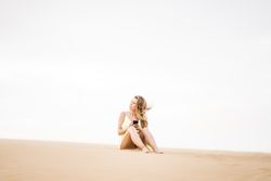 Happy woman using smartphone in desert