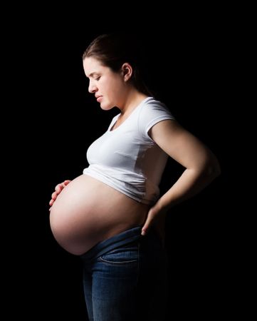 Beautiful expectant pregnant woman looking her belly isolated