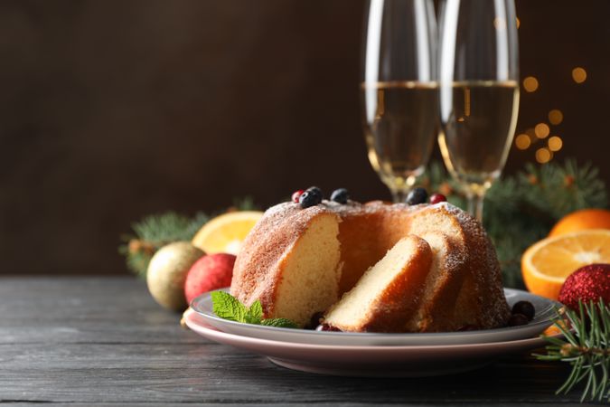 Cake with powdered sugar, berries and mint on wooden background, copy space