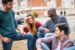 Male and female friends laughing and smiling together in city