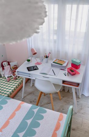 Desk in girl's bedroom decorated in pastel colors