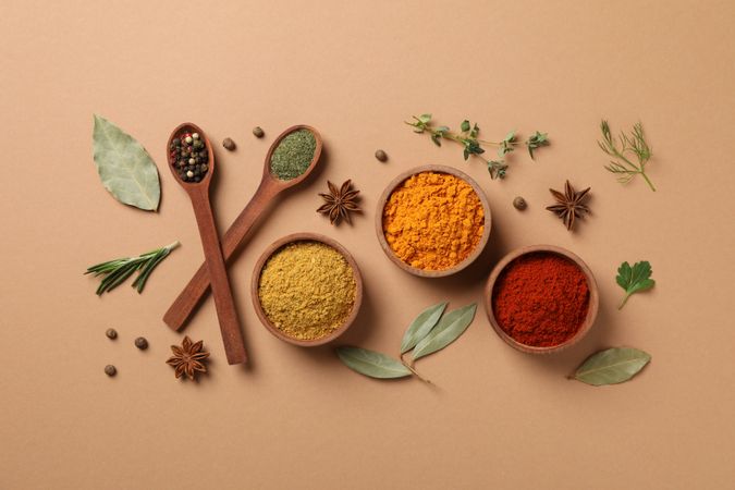 Top view of bowls of cumin and turmeric with wooden spoons