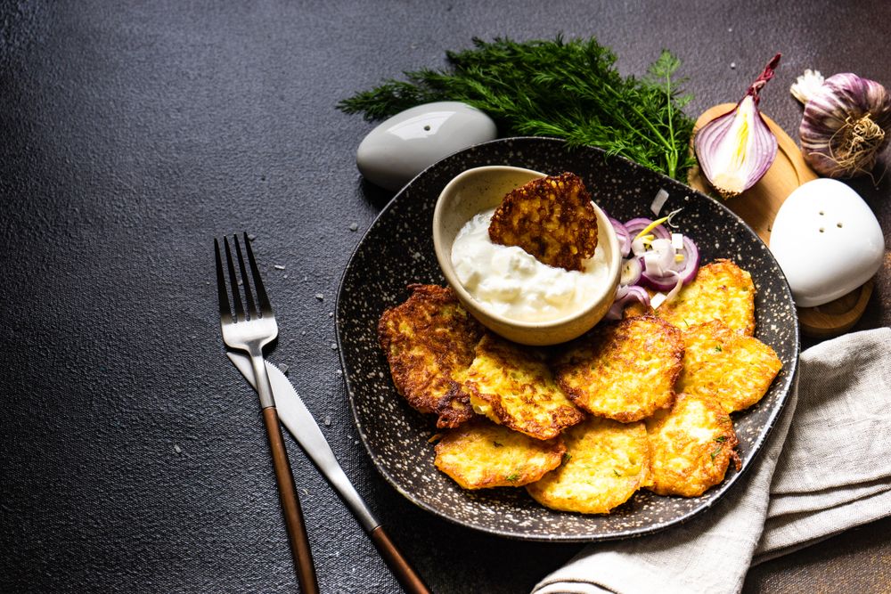 Top view of traditional Ukrainian dish deruny with dipping sauce and dill