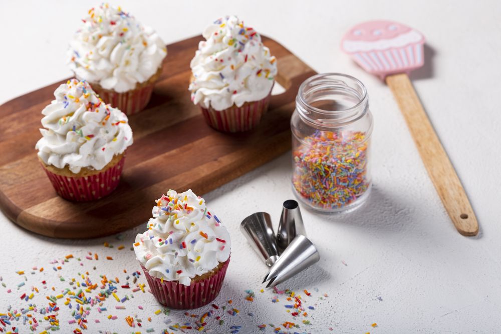 Tasty party cupcakes on the table. Cupcakes with whipped cream.