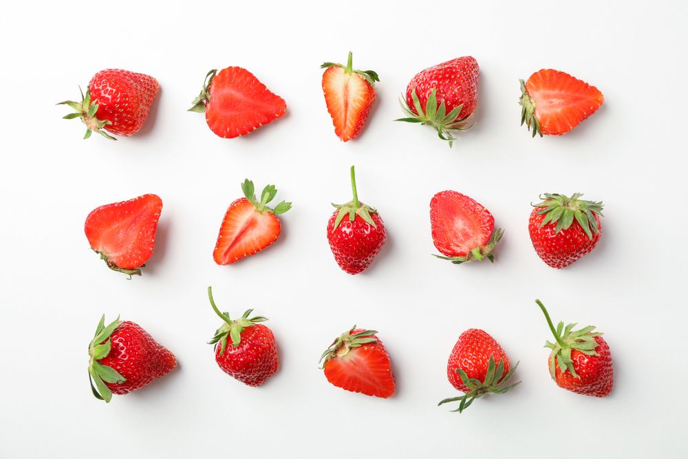 Flat lay composition with strawberries on light background, space for text. Summer sweet fruits and berries