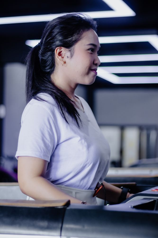 Focused woman exercising on treadmill in modern lighted gym