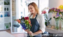 Happy female florist creating bouquet of flowers at her shop 5wWQA5