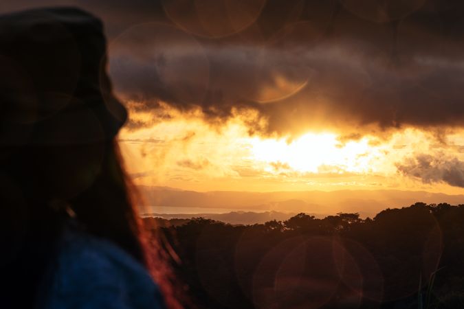Woman watching the sunset in the countryside in Costa Rica
