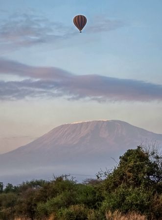 Hot air balloon flying over Mount Kilimanjaro at dawn in Amboseli National Park, Kenya