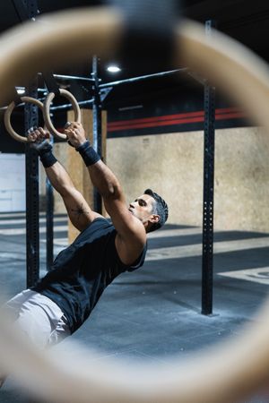 Hispanic sportsman exercising with gymnastic rings