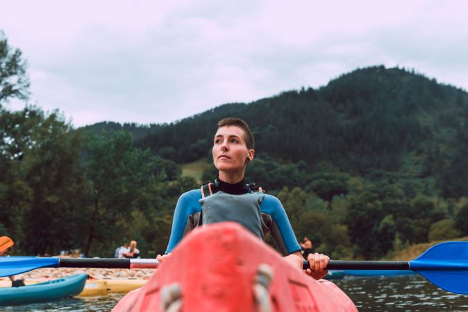 Young female kayaking on nature background