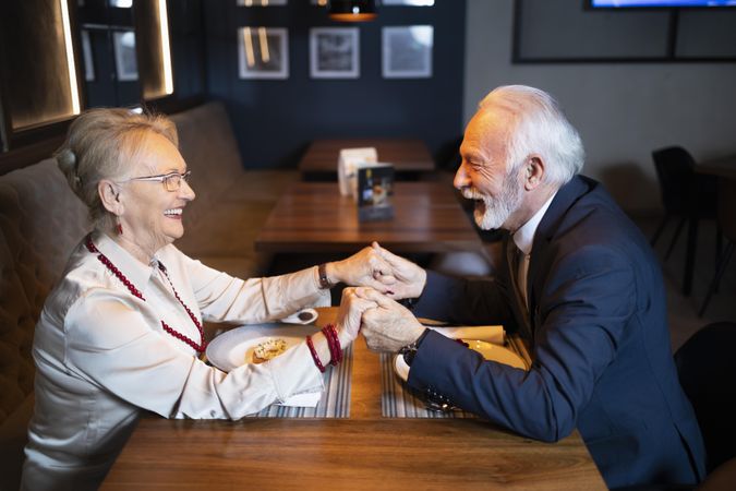Mature man and woman smiling on a date in a quiet restaurant