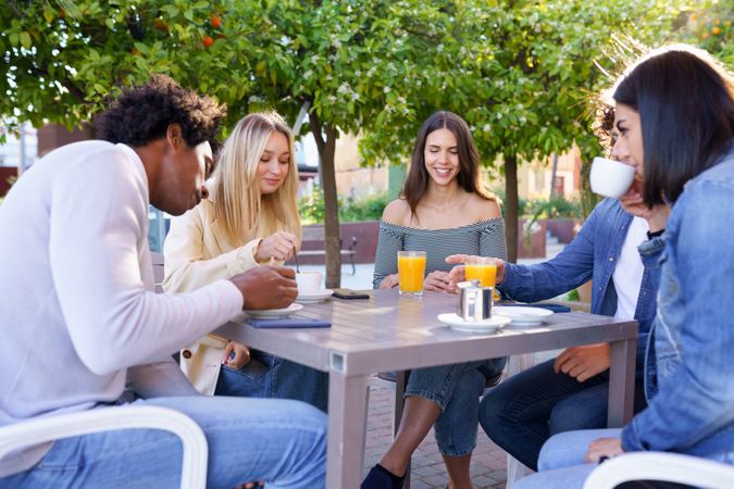 Young people having coffee and juice outside