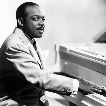 American jazz bandleader and pianist Count Basie, seated at the piano, in 1955