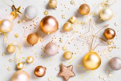 Golden baubles, star decorations and star glitter on plain backghground