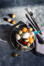 Top view of Easter table setting with bowls of different sized eggs