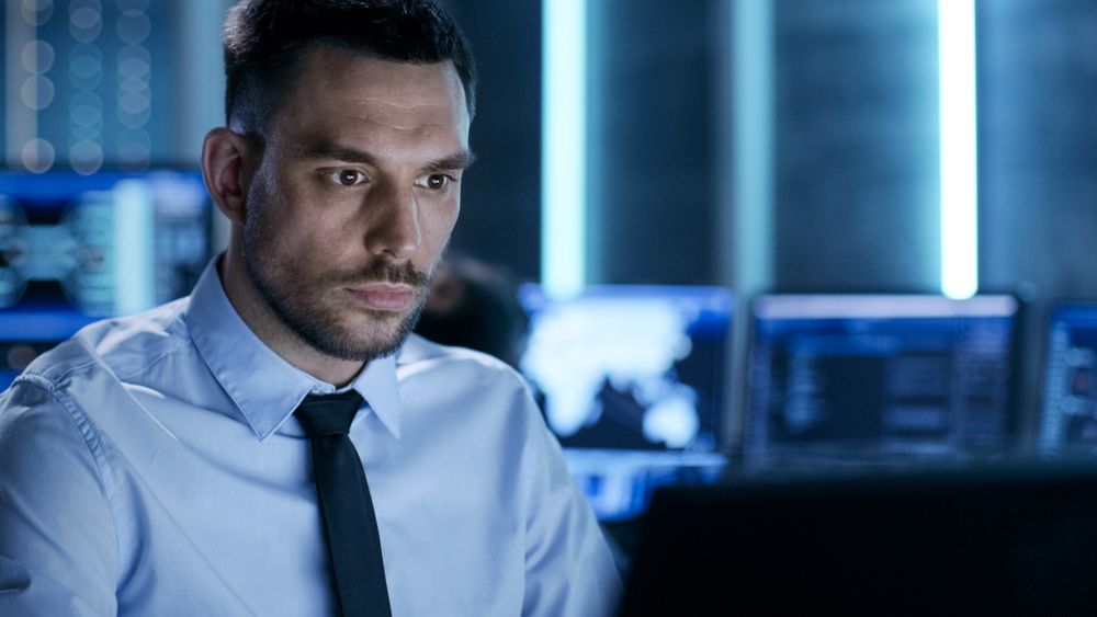 Professional Technical Controller with Colleagues at Their Workstations.