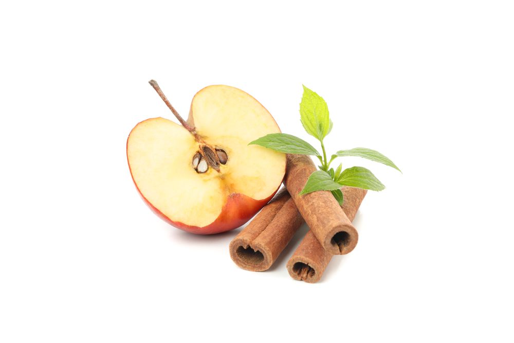 Half of apple with cinnamon sticks
