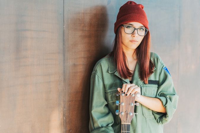 Woman in glasses leaning on wall