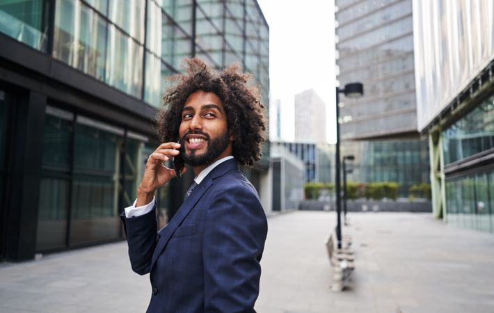 Curly man smiling at street