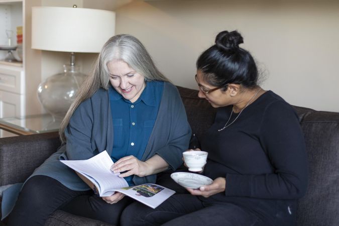 Happy women reading a magazine together