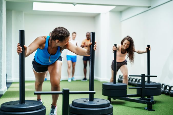 Two woman pushing heavy weights in the gym