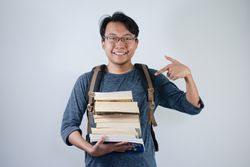 Asian young male student doing pointing gesture