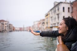 Asian female on vacation on ferryboat on waterline at city