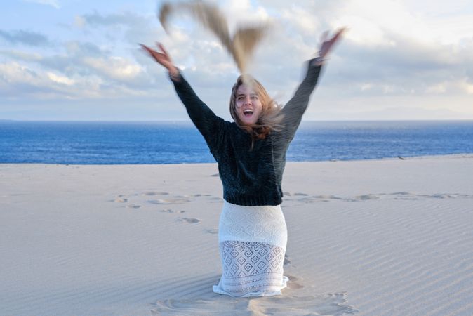 Woman throwing sand on beach