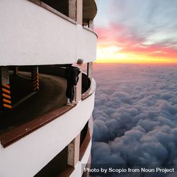 Person standing on balustrade above the cloud during sunset 4Nrkl4
