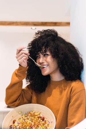 Cheerful Black woman eating healthy salad