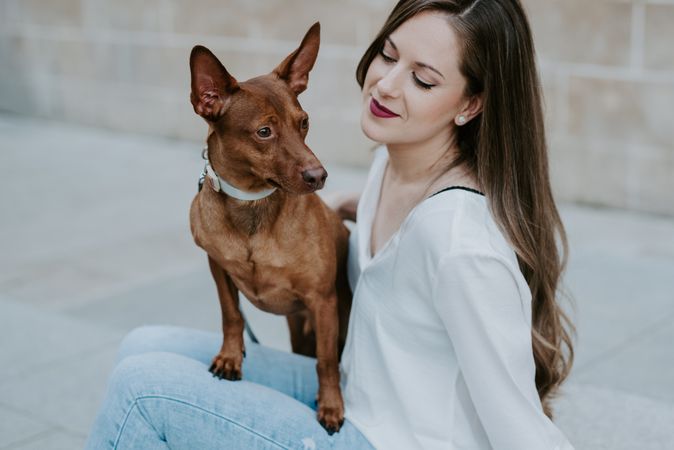 Woman with purebred dog on stone porch