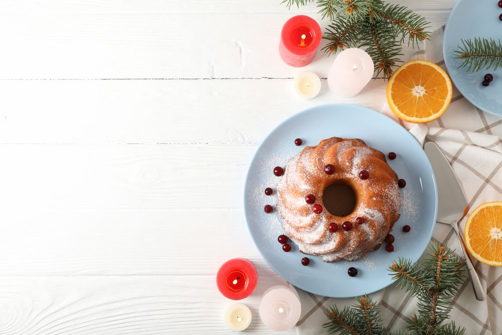 Cake with powder sugar and cranberry on table. Christmas concept
