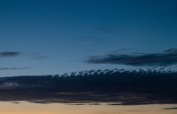 Long grey clouds in blue sky