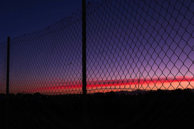 Net fence against sunset sky