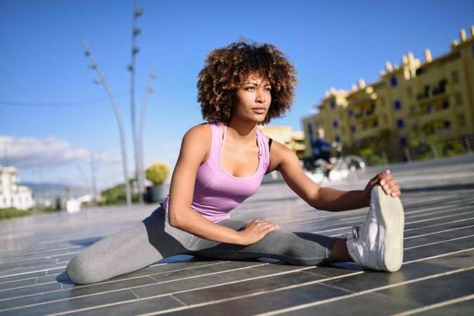 Female with afro cooling down with cityscape in the background