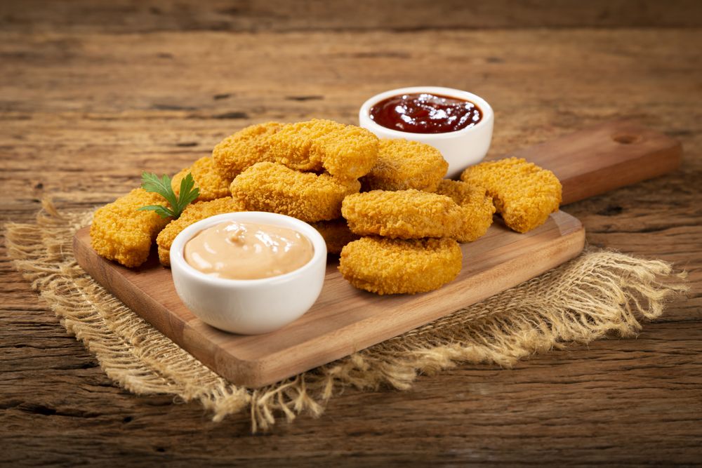 Fried chicken nuggets with ketchp and rose sauce.