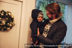 Man with his baby boy in sweaters and coats at home during Christmas 0ydBRb