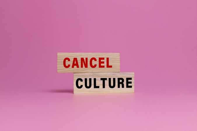 cancel culture words on wooden blocks isolated on pink background