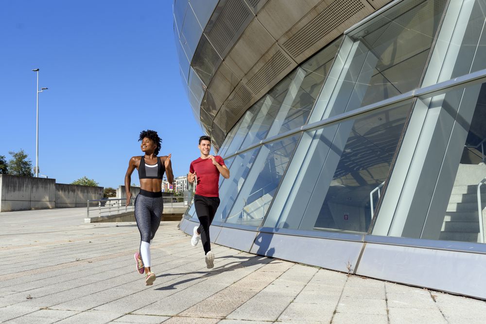 Modern active sportspeople running in city