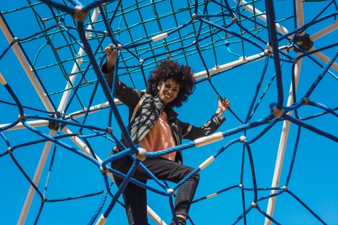Woman with afro hair climbing by children's attractions.
