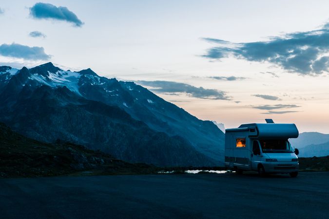 Camper car on road along snowy mountains