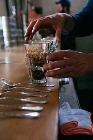 Close up of man’s hands near empty glasses for coffee tasting