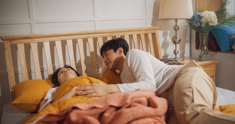 Young Korean Couple Sleeping in Bed, Caring Husband Waking up His Wife, Getting Ready for New Day.