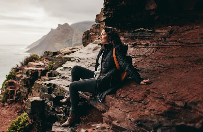 Beautiful woman resting on mountain top and contemplating the view