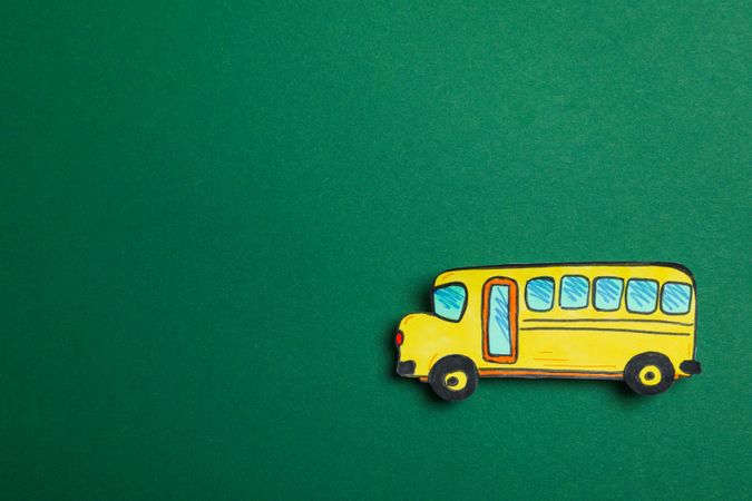 Decorative school bus on green background, space for text