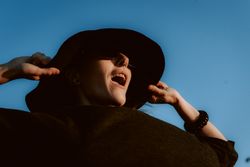 Dreaming stylish woman in sunglasses and hat