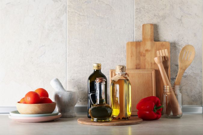 Kitchen table with different supplies and bottles with oil