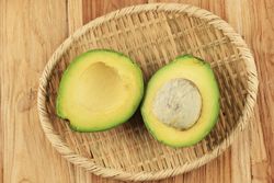 Avocado halves in bamboo bowl